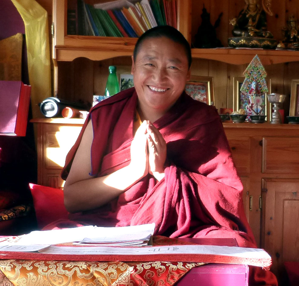 Lama Öser a senior Buddhist monk with his hands held in prayer position.