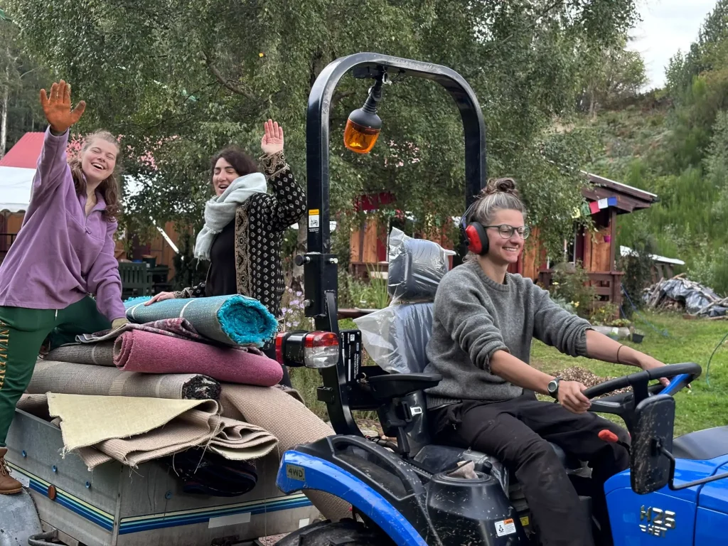 Residential volunteers on a blue tractor at Buddhist Centre Scottish Highlands